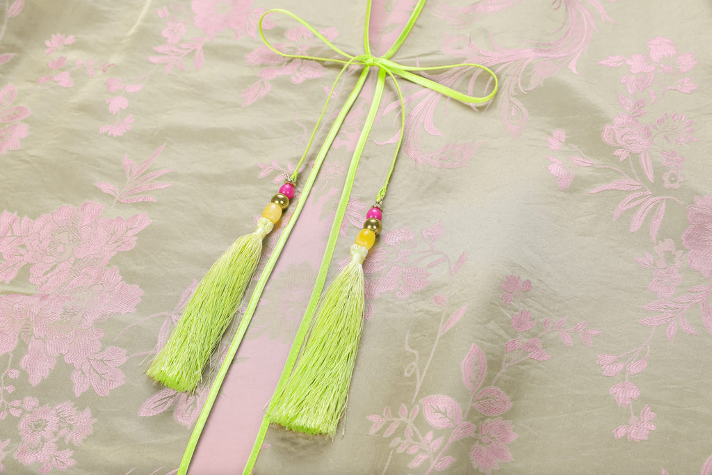 Chinese Silky Phoenix Brocade Abaya (Neon Green) — close-up of neon-green ties and tassels against pink patterned brocade